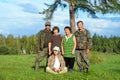 Two Yakut Asian elderly couples men and women with a young girl sitting on the grass pose for a family photo