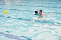 Two year boy at first swimming lesson with his mother