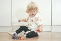 Two year old boy with hands and face painted in colorful paints ready for more fun. dirty and happy kid sitting on the Royalty Free Stock Photo