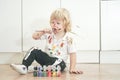 Two year old boy with hands and face painted in colorful paints ready for more fun. dirty and happy kid sitting on the Royalty Free Stock Photo