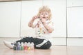 Two year old boy with hands and face painted in colorful paints ready for more fun. dirty and happy kid sitting on the Royalty Free Stock Photo