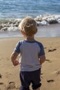 A two year old boy playing on a beach in Maui