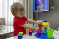 A two year old child is playing with a set of modeling colored plasticine sitting at a table. Royalty Free Stock Photo