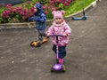 Two year old children riding a scooter in a park. Royalty Free Stock Photo