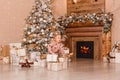 Two-year-old girl in a costume with a Christmas print and gifts under the Christmas tree Royalty Free Stock Photo