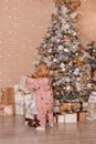 Two-year-old girl in a costume with a Christmas print and gifts under the Christmas tree Royalty Free Stock Photo