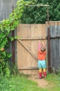 Two year-old toddler girl is reaching up door swivel hook Royalty Free Stock Photo