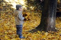 Two years old boy standing near tree
