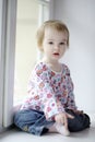 Two years old girl sitting by the window Royalty Free Stock Photo