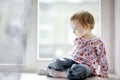 Two years old girl sitting by the window Royalty Free Stock Photo