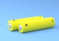 Two yellow AA size batteries isolated on blue background Royalty Free Stock Photo
