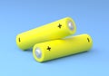 Two yellow AA size batteries isolated on blue background in pastel colors Royalty Free Stock Photo