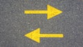 Two yellow arrows on the asphalt. Concept, radically different directions Royalty Free Stock Photo