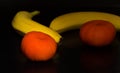 two yellow bananas and two orange tangerines Royalty Free Stock Photo