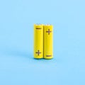 Two yellow batteries on a blue background Royalty Free Stock Photo