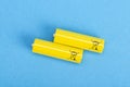 Two yellow batteries on a blue background, top view Royalty Free Stock Photo