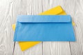 Two yellow and blue envelopes with letters on white wooden background. Blanks for the designer. Concepts, ideas for postal service Royalty Free Stock Photo