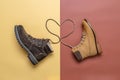 Two yellow and brown men`s and women`s winter suede leather stylish boots on color background. Laces in heart shape. Casual tren Royalty Free Stock Photo