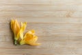 Two yellow colored plucked flowers on wooden background. These flowers are called as Michelia champaca also known as sonchampa