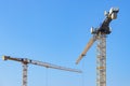 Two yellow cranes on a construction site against the blue sky, copy space, selected focus Royalty Free Stock Photo