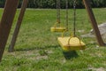 Yellow swings in garden or park without children.