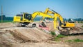 Two yellow excavators and a dump truck Royalty Free Stock Photo