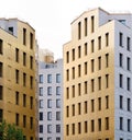 Two yellow facades of the city office buildings with grey construction behind them. Sunset lighting Royalty Free Stock Photo