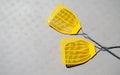 Two yellow fly swatters lying on a gray picnic table Royalty Free Stock Photo