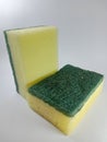 Two yellow-green dishwashing sponges on a white background