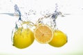 Two yellow lemons and lemon slice spash in water on white background Royalty Free Stock Photo