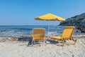 Two Yellow Lounge Chairs On The Beach By The Sea
