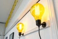 Two yellow neon light bulbs on white wall Royalty Free Stock Photo