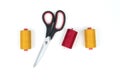 Yellow and red sewing thread coils with big black scissors on a white background Royalty Free Stock Photo