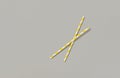 Two yellow paper straw on gray background