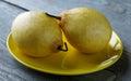 Two yellow pears on the plate on a table Royalty Free Stock Photo