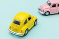 Two yellow pink vintage retro toy car isolated on blue pastel colorful background Royalty Free Stock Photo