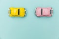 Two yellow pink vintage retro toy car isolated on blue pastel colorful background Royalty Free Stock Photo