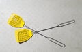 Two yellow fly swatters lying on a gray picnic table Royalty Free Stock Photo