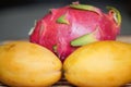 Two yellow ripe mangoes and a dragon fruit Royalty Free Stock Photo