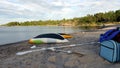 Two yellow, white and green canoes placed upside down on the beach to dry after a row Royalty Free Stock Photo