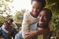 Two young adult black couples piggybacking look to camera Royalty Free Stock Photo