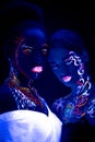 Two young african and caucasian girls with fluorescent make-up Royalty Free Stock Photo