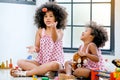 Two young African girls play together that older throw some toys and younger girl look fun with the activity
