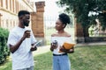 Chatting with friends. Two young african man and woman talking to each other and smiling