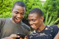 two young african men viewing interesting content on a phone together