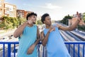 Two young men wearing sleeveless t-shirt taking a selfie on footbridge in the city Royalty Free Stock Photo