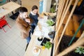 Two young architects looking over building plans during a meeting in a modern cafe Royalty Free Stock Photo