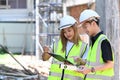 Two young architects discussing, planning development details together at construction site Royalty Free Stock Photo