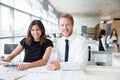 Two young architects working in an office, smiling to camera Royalty Free Stock Photo