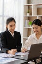 Two young Asian accountants discuss working